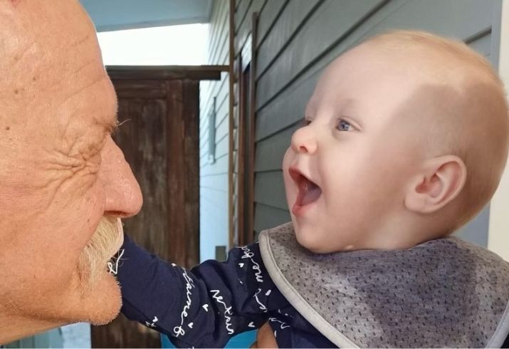 Frank and his grandchild touching his face.