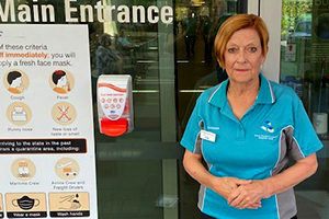 Lady standing next to main entrance sign