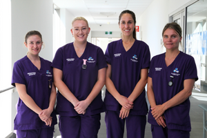 Four FSH midwifery graduates standing together smiling