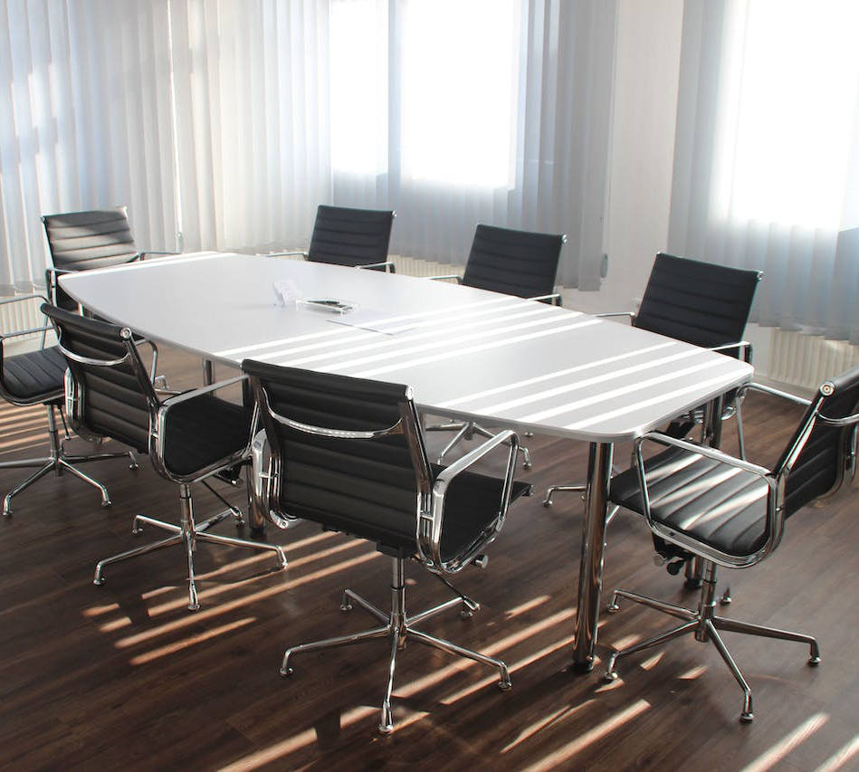 empty boardroom: white table and and 7 black chairs