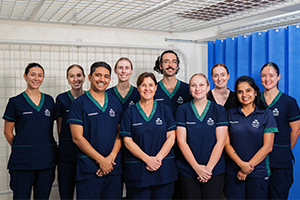 A group of ten members of the Spinal bracing project at Peel Health Campus stand together