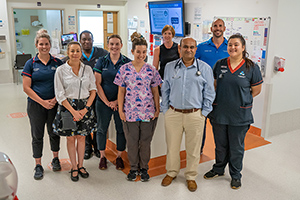 A group of nine people standing in a hospital ward