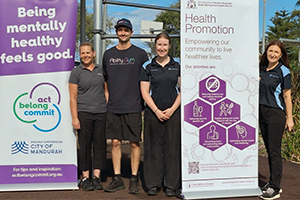SMHS Health Promotion staff stand with community partners in front of falls prevention signage