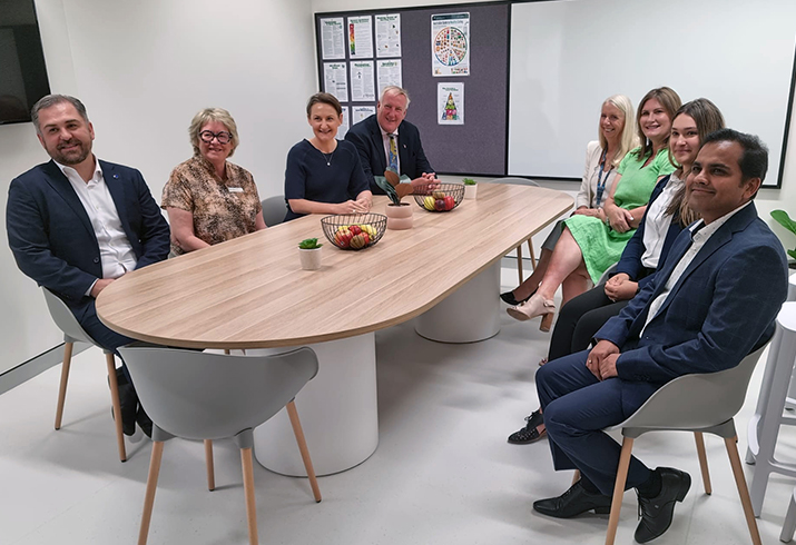 A group of eight people, including Minister for Health Amber-Jade Sanderson (third from left) sit around a table at the opening of the Kara Maar Specialist Eating Disorder Clinic