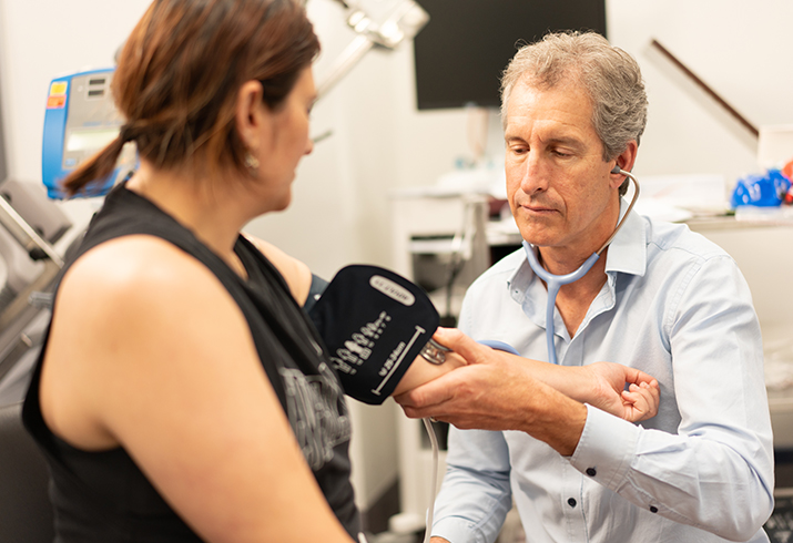 A male health professional takes the blood pressure of a female patient
