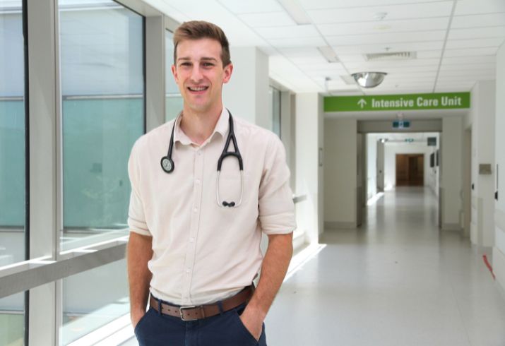 Trial investigator Dr Henco Nel standing in a hallway with his hands in pockets, with the ICU sign in the background behind him.