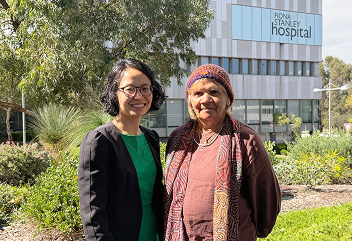 Dr Stephanie Lam stands outside with Aboriginal patient Loreta. The Fiona Stanley Hospital building is in the background