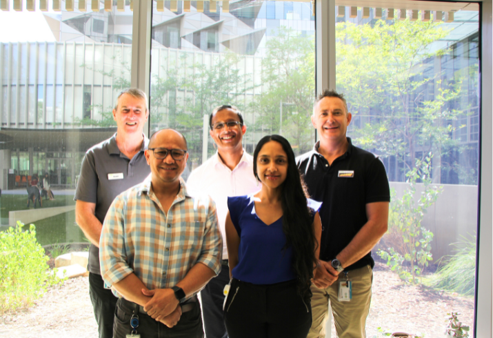 Work colleagues stand together smiling