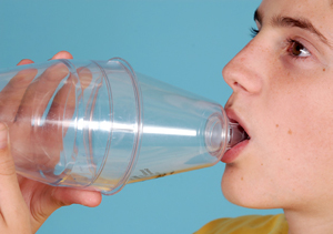 person fitting mouth over mouthpiece of spacer